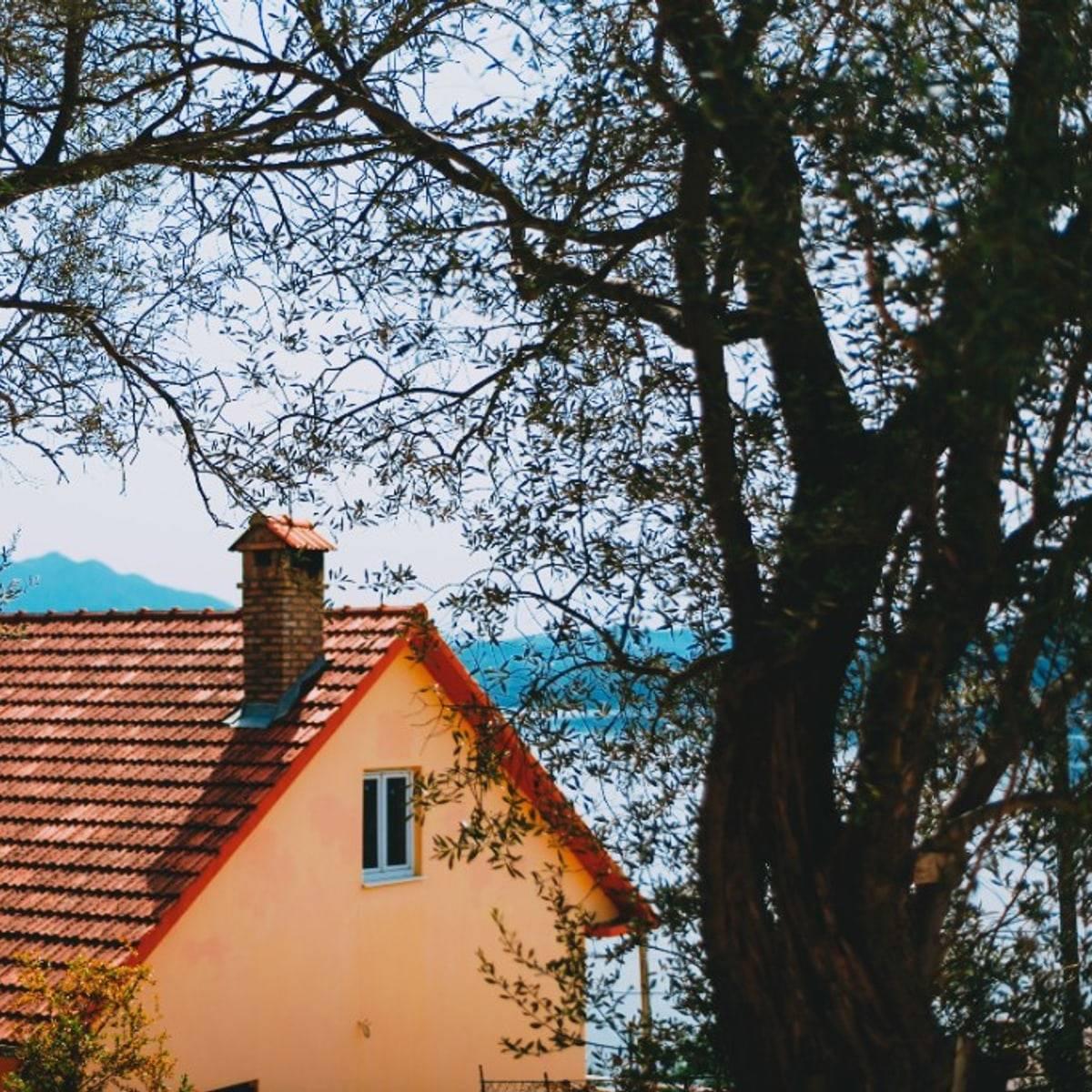 House with a clay tile roof and chimney in Poothole